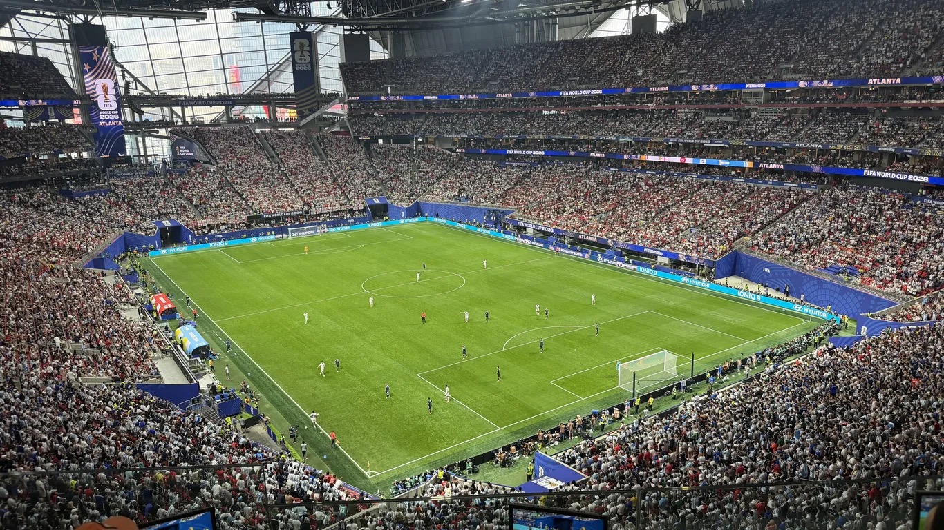 A packed Mercedes-Benz Stadium seen from the upper deck during the England versus Argentina World Cup semifinal, with FIFA World Cup 2026 Atlanta signage ringing the bowl.