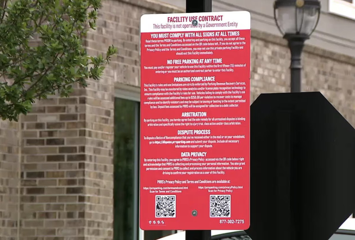 A private parking lot's posted facility-use contract sign in Atlanta, listing enforcement, dispute and data-privacy terms