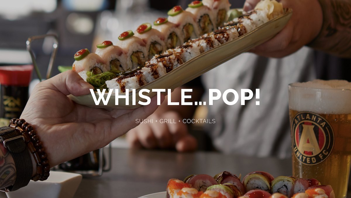A platter of Bottle Rocket sushi rolls handed across the bar beside a pint of beer in an Atlanta United glass