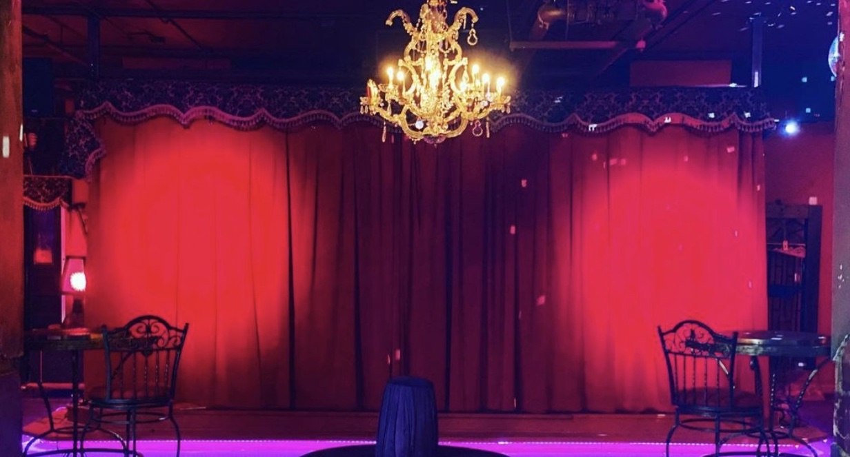 Red-curtained stage with chandelier inside an Underground Atlanta nightlife venue