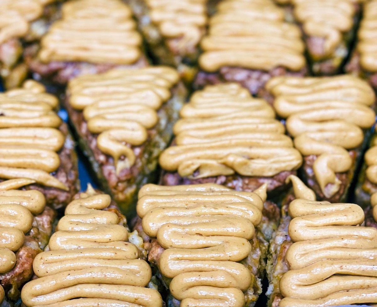 Rows of Flaky Not Flaky baked treats topped with piped tan frosting