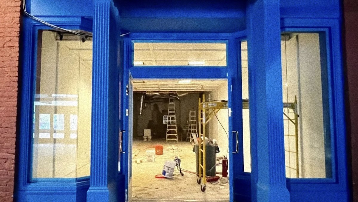 Blue-painted storefront of Foster at Underground Atlanta, with ladders and scaffolding visible inside the suite during renovation