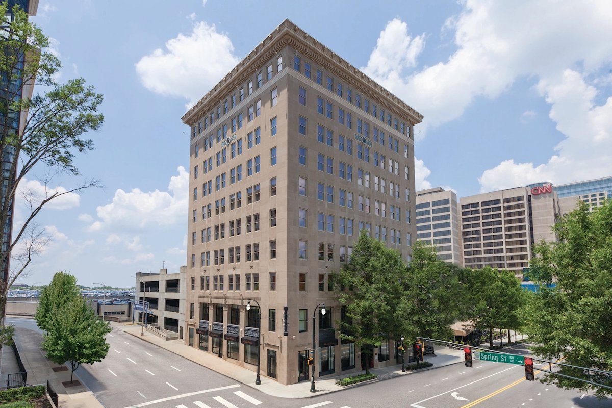 The tan stone Glenn Building at Marietta Street and Ted Turner Drive in downtown Atlanta, with the CNN Center visible behind it