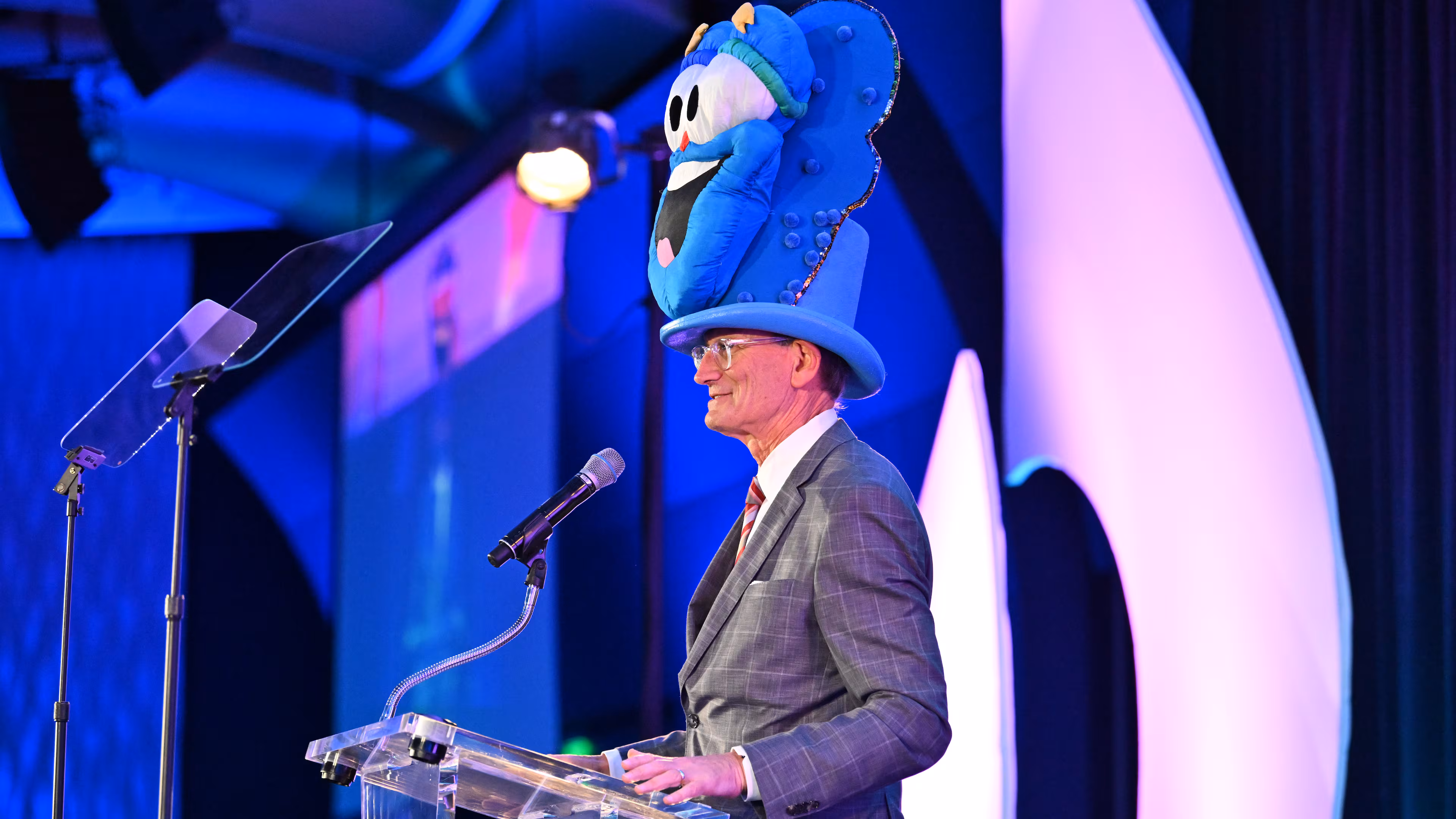 Wearing a hat featuring 1996 Olympics mascot Izzy, A.J. Robinson speaks during the Central Atlanta Progress and Atlanta Downtown Improvement District annual meeting and awards celebration Wednesday, March 11, 2026, at the Georgia Aquarium in Atlanta.