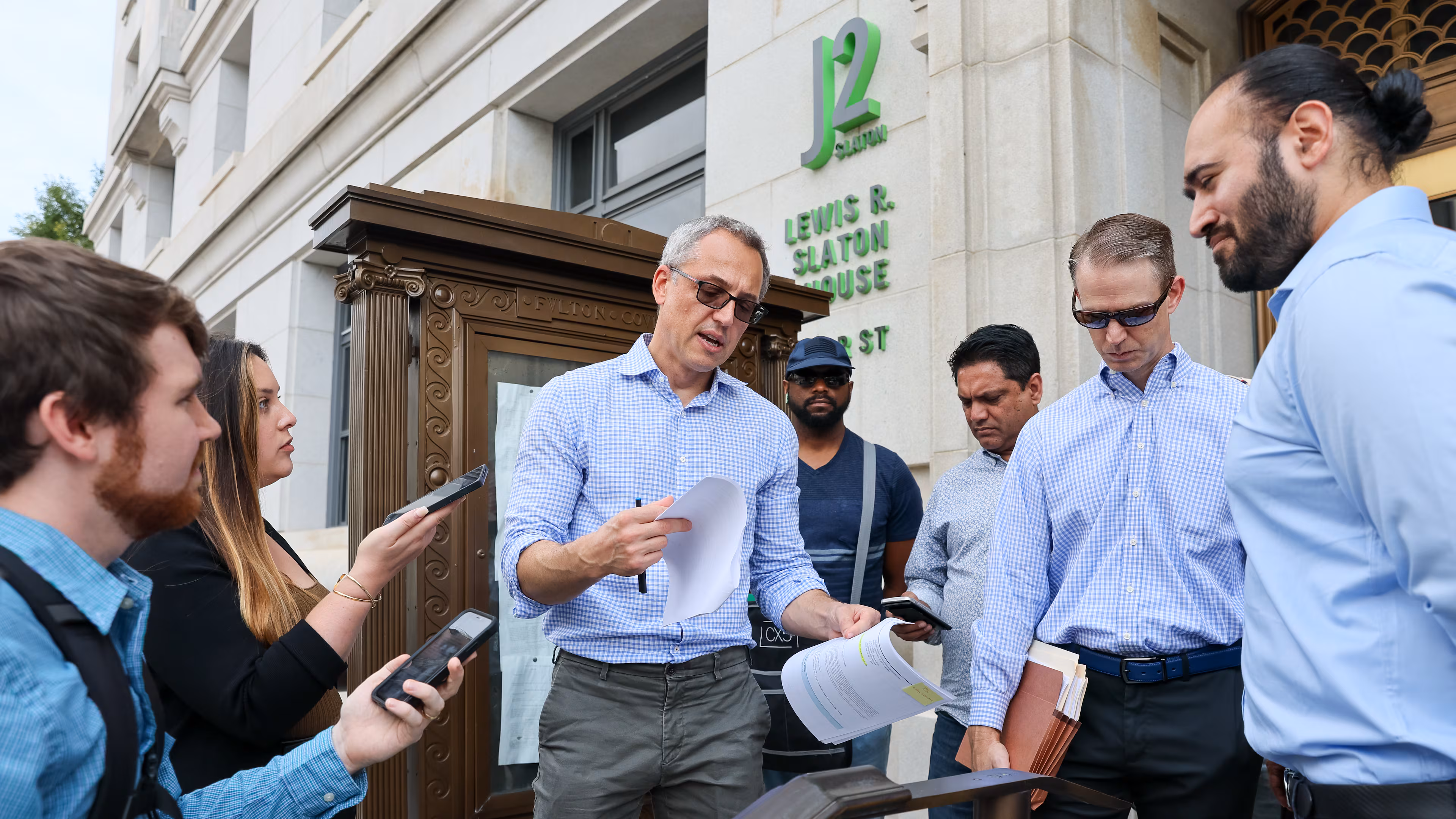 Attorney Bob Stupar reads the 32-page foreclosure listing for Peachtree Center in front of the Fulton County Courthouse in Atlanta on September 6, 2022.