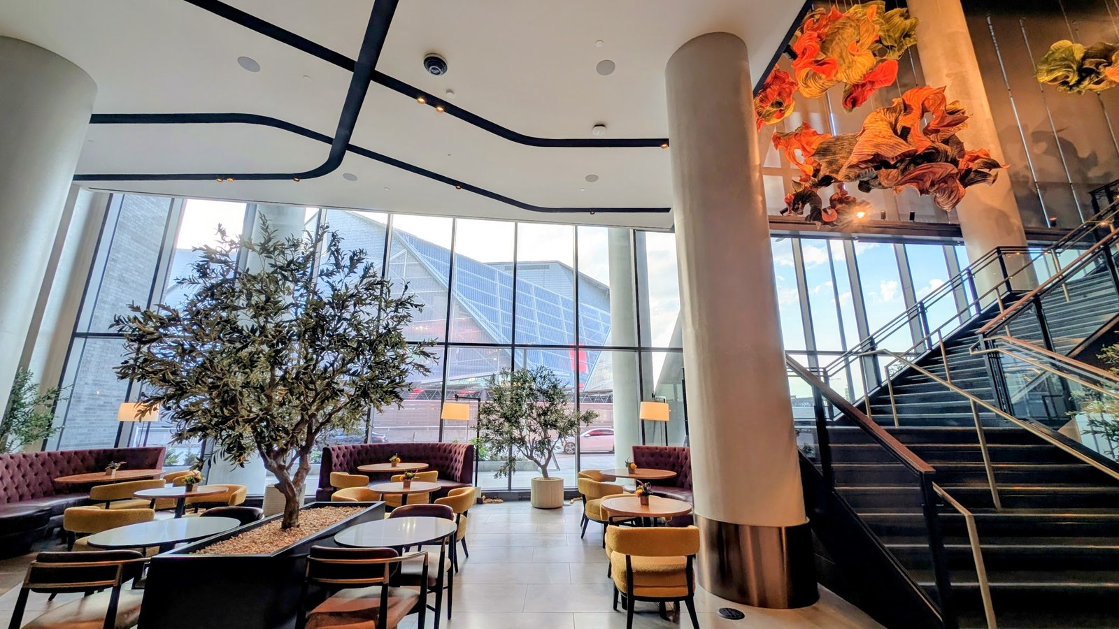 Lobby lounge at Hotel Phoenix in Centennial Yards, with floor-to-ceiling windows framing Mercedes-Benz Stadium
