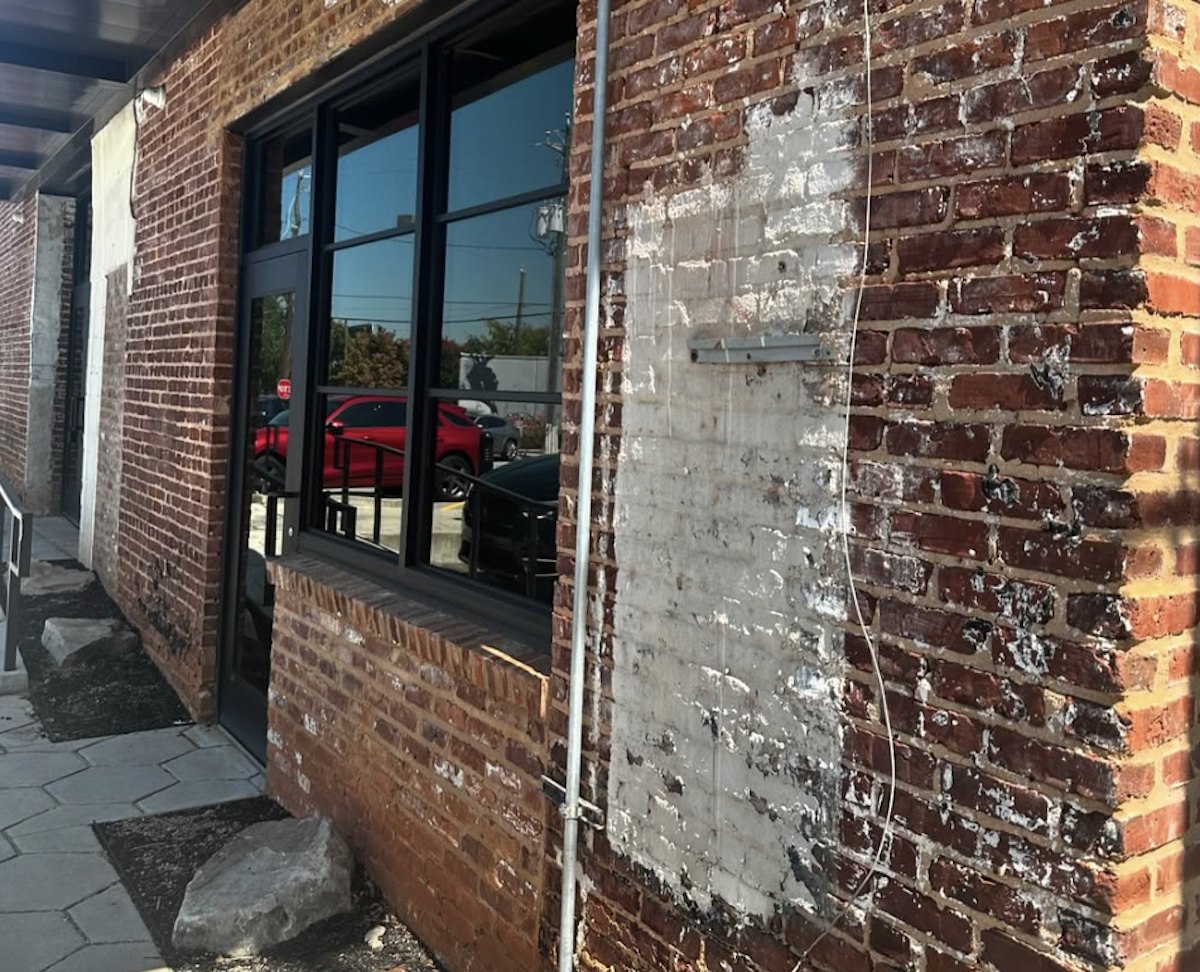 Red brick storefront with large black-framed windows at 131 Walker Street SW in Castleberry Hill, future home of Kodak Smoothies and Koffee