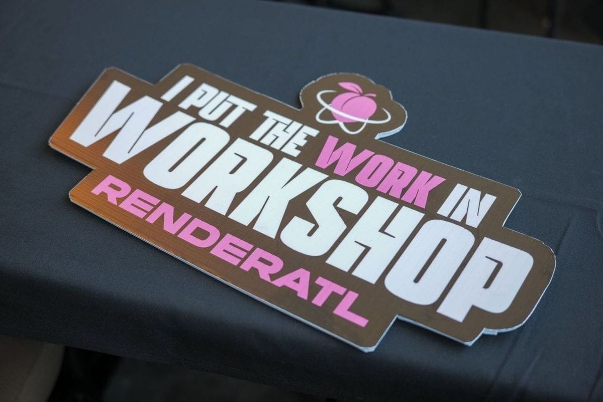 A RenderATL sign reading 'I put the work in workshop' with a peach logo, lying on a dark table cloth