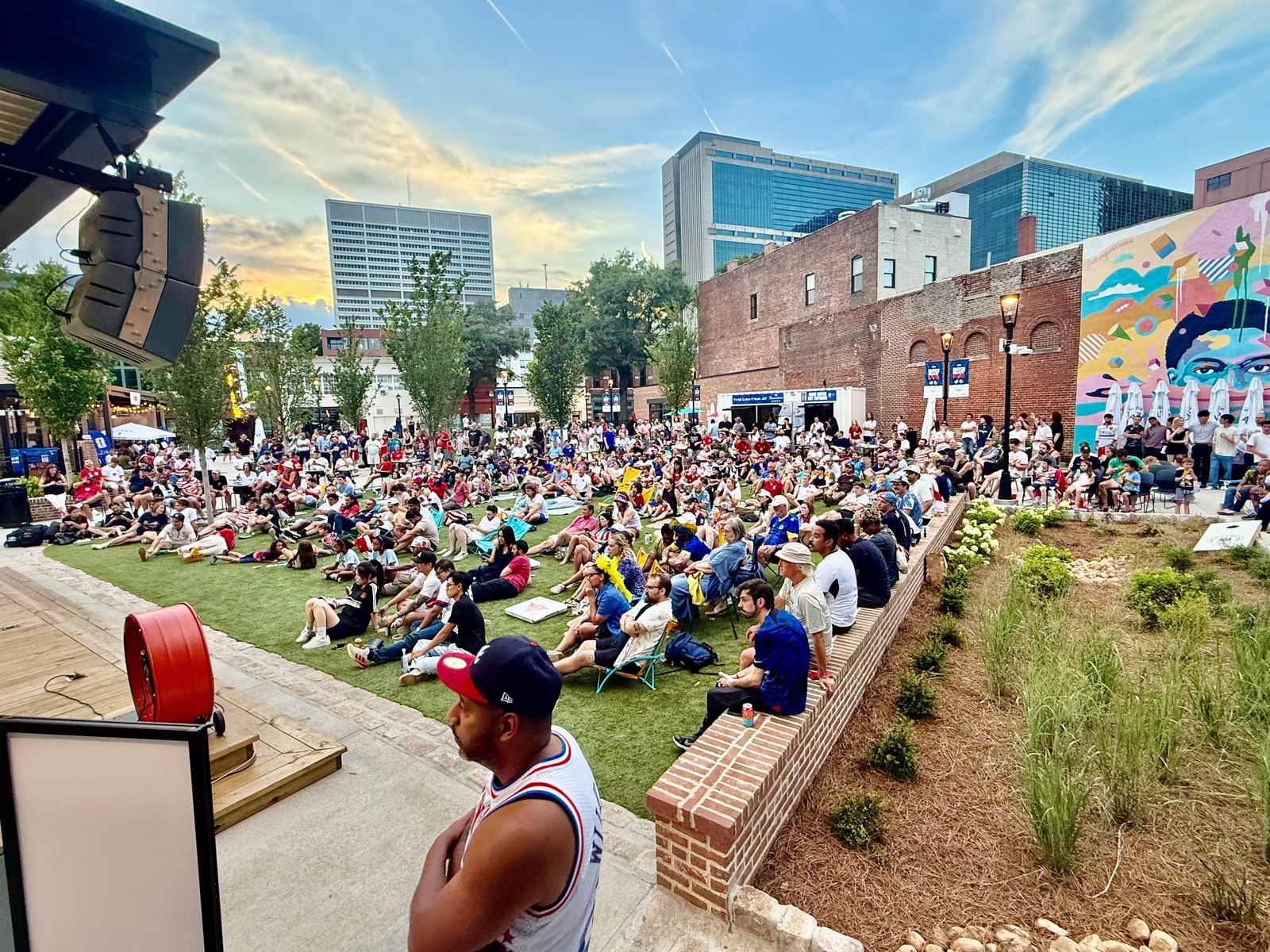 Soccer fans gather on the lawn at Founders Green in South Downtown for a World Cup watch party
