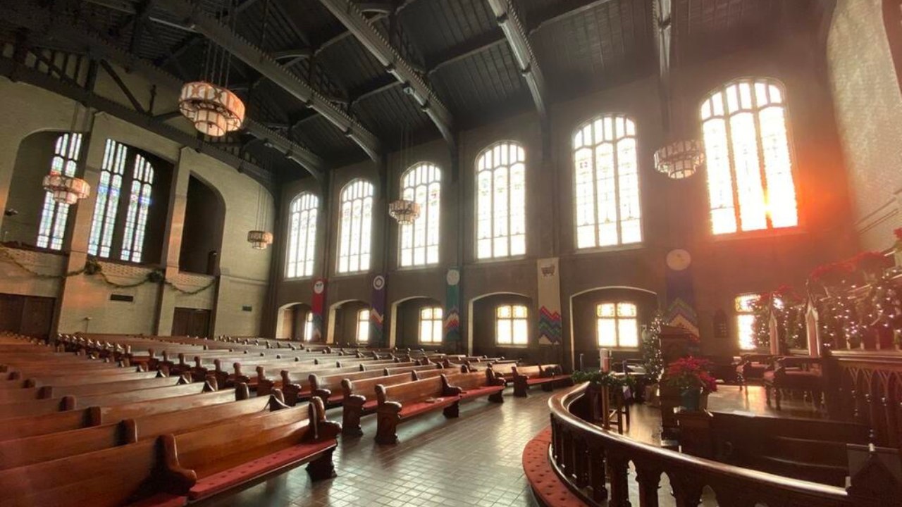 Interior of the Trinity United Methodist Church sanctuary in downtown Atlanta with wooden pews and tall arched stained glass windows
