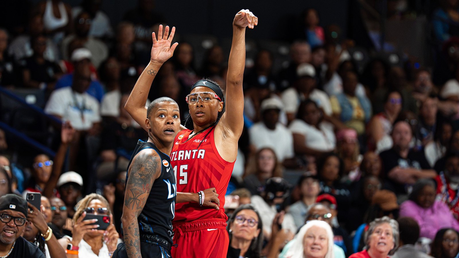 Atlanta Dream guard Allisha Gray in a red ATLANTA number 15 uniform releases a jump shot before a packed State Farm Arena crowd