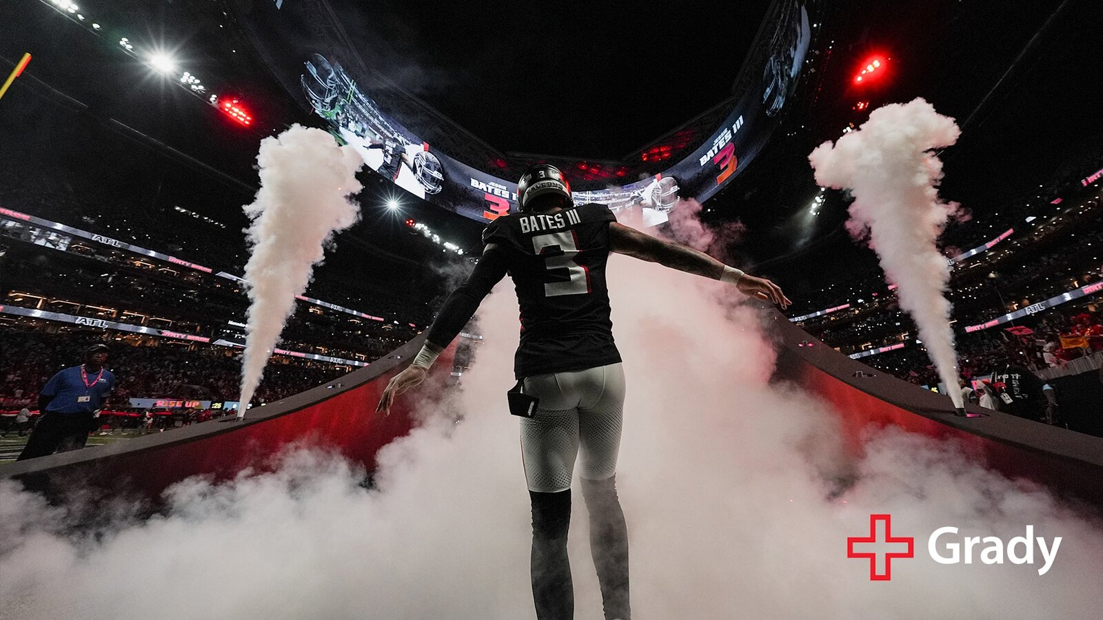 Atlanta Falcons safety Jessie Bates III in the black number 3 home jersey walks onto the field through jets of white smoke during player introductions at Mercedes-Benz Stadium