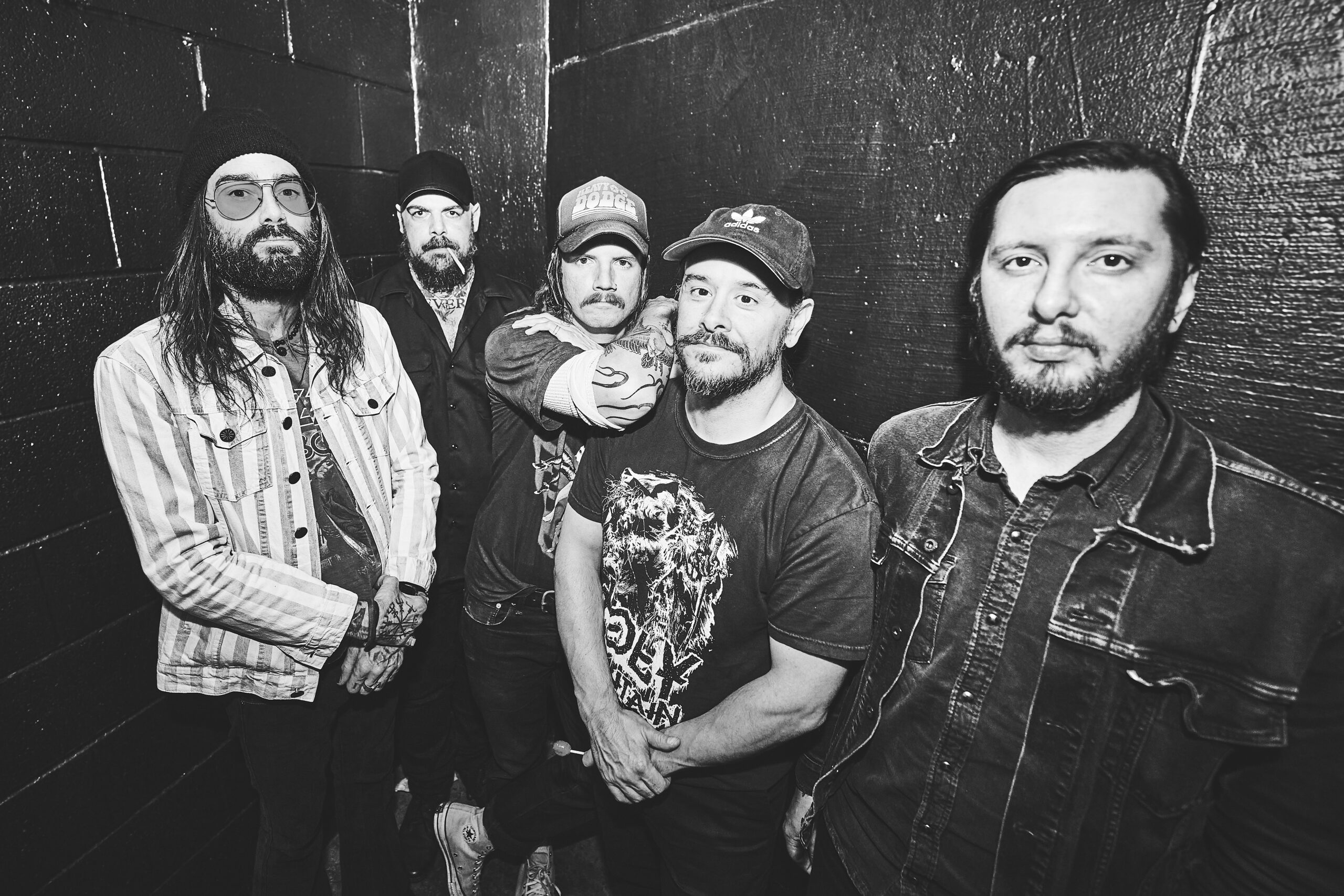 Black-and-white portrait of the four members of southern metal band He Is Legend standing together outdoors.
