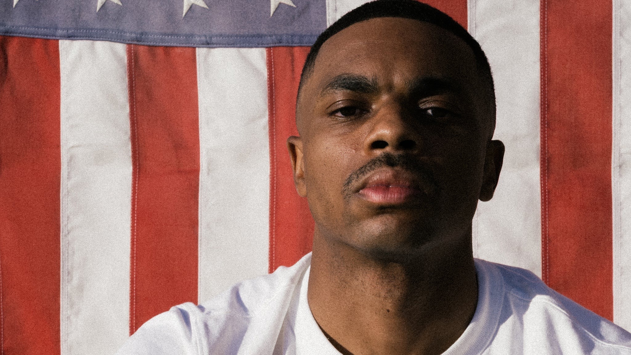 Rapper Vince Staples in a white T-shirt standing in front of an American flag, official key art for his 2026 Cry Baby Tour stop at The Tabernacle in Atlanta.